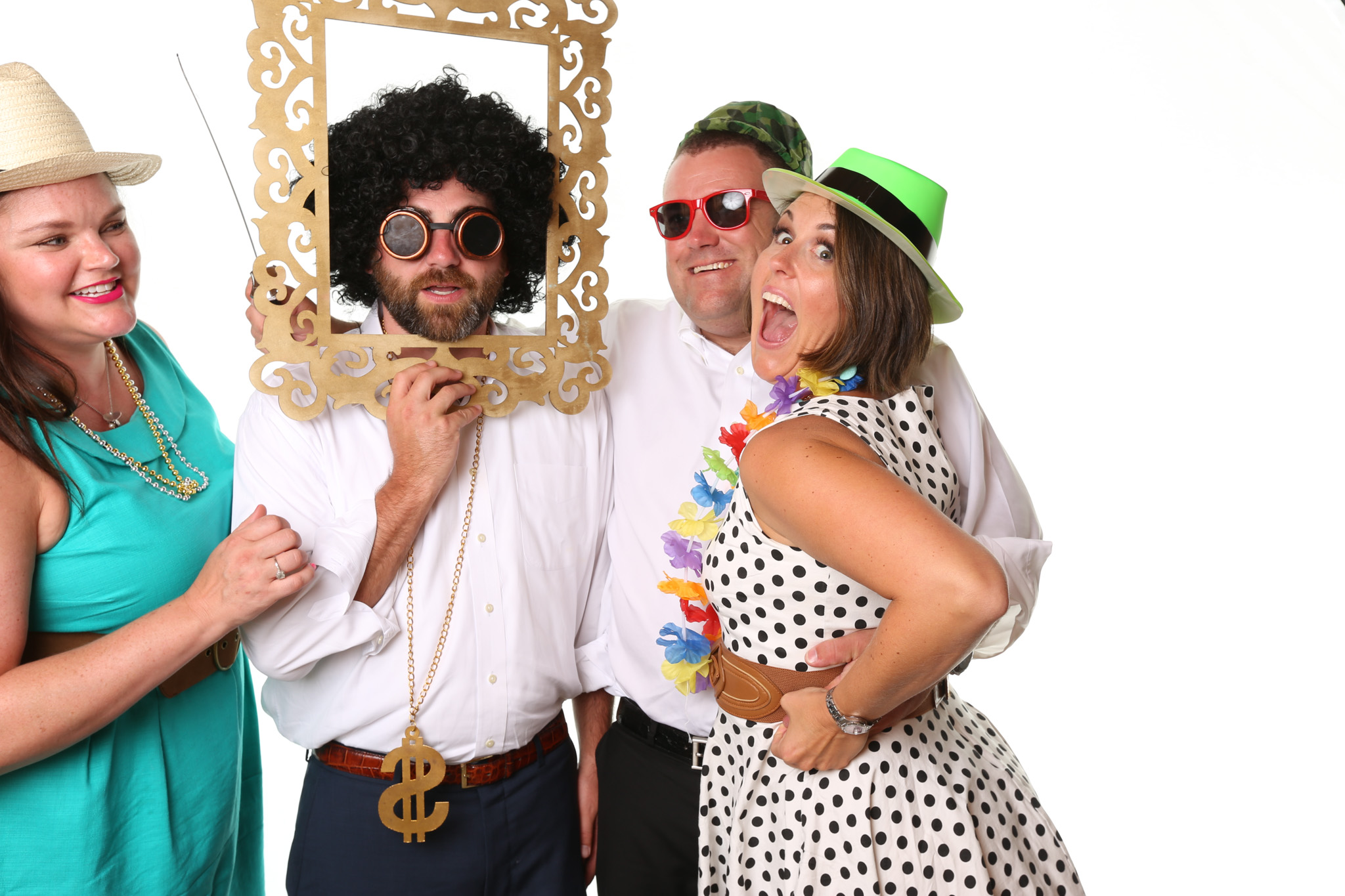 Guest at wedding in Asheville, NC using Forge Mountain Photography's photo booth. Guest are psing on a completely white background with no shadows. They are using all sorts of props like viking helmets, fake beards, wigs, and musical instruments.