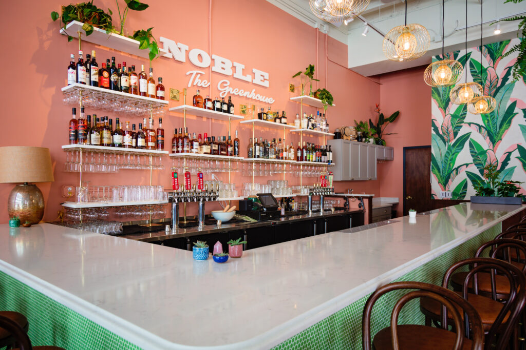 View from the corner seat area of the bar at "The Greenhouse". The walls are pink with green tile. 