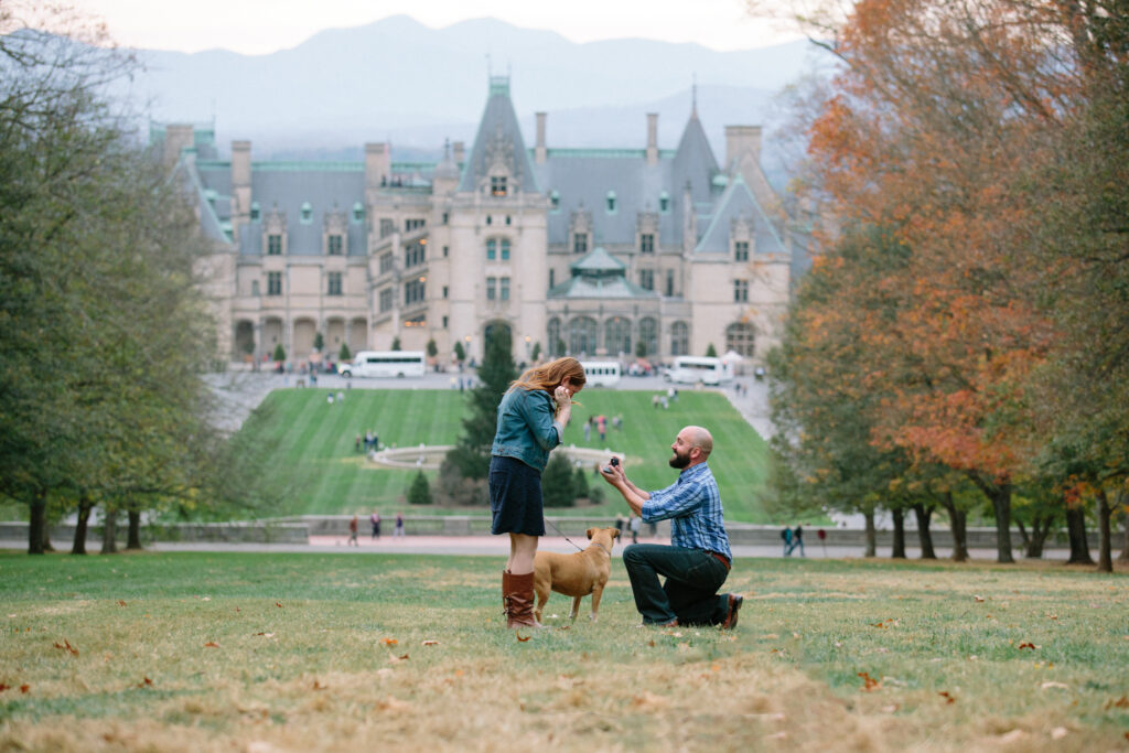 Eser on one knee proposing to Eileen at Biltmore Estate in Asheville. The photographer is hidden behind Diana statue