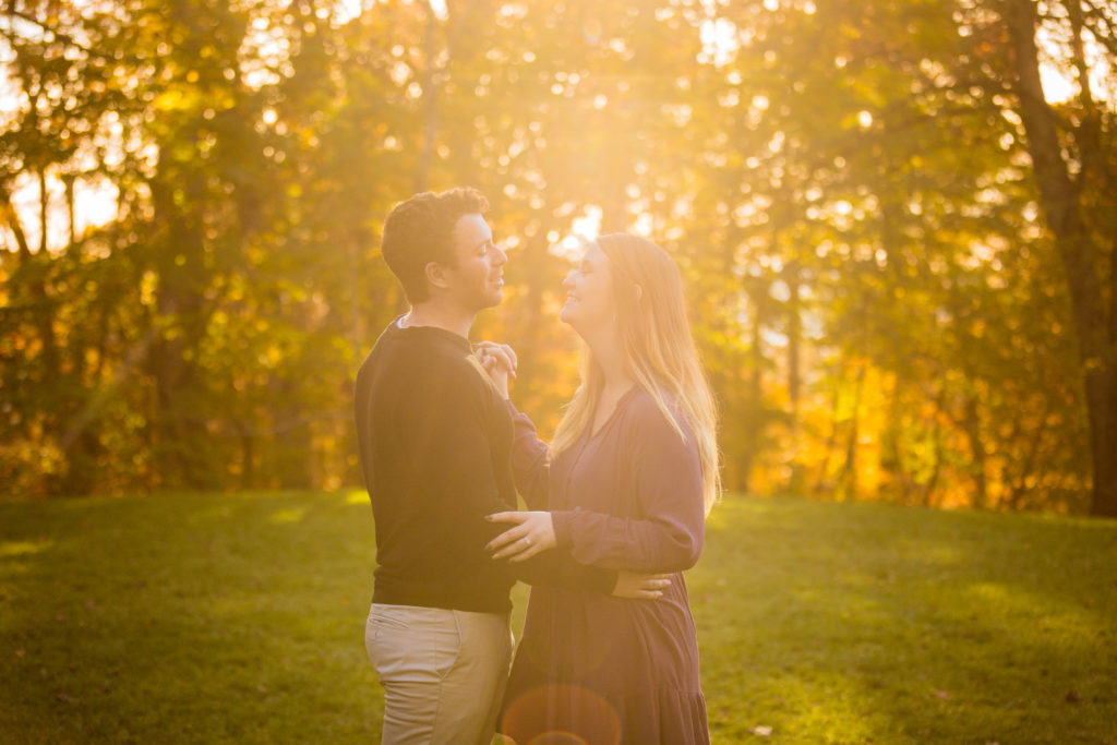 Couple standing in the glowing light from the fading sun after proposal on Biltmore Estate