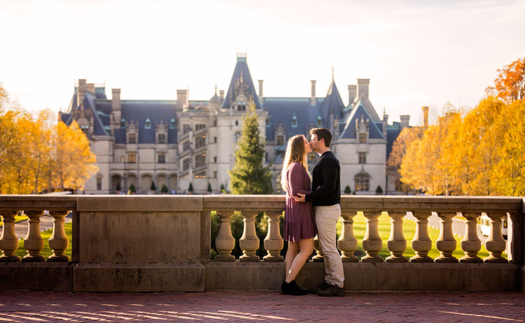 One the landing at Biltmore Estate kissing for engagement photos