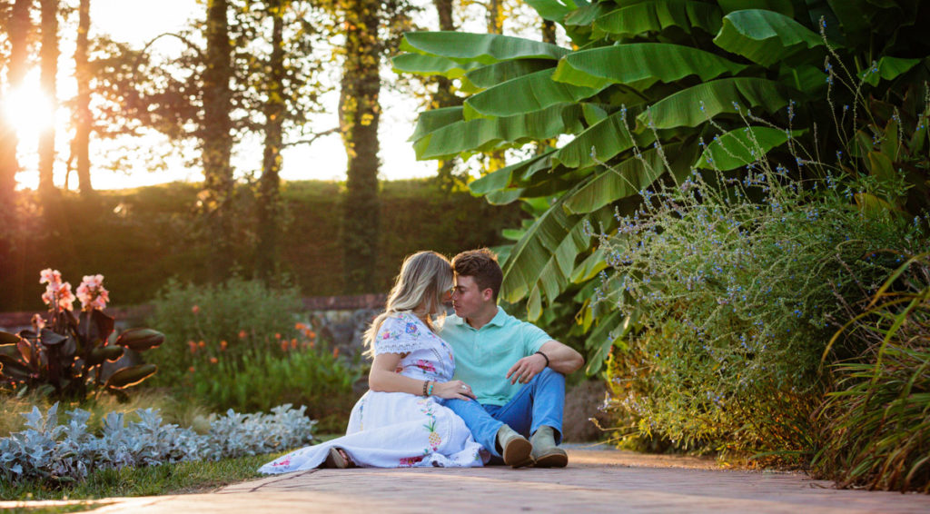 Couple embracing one another on a brick path in the gardens for the Biltmore Boathouse proposal