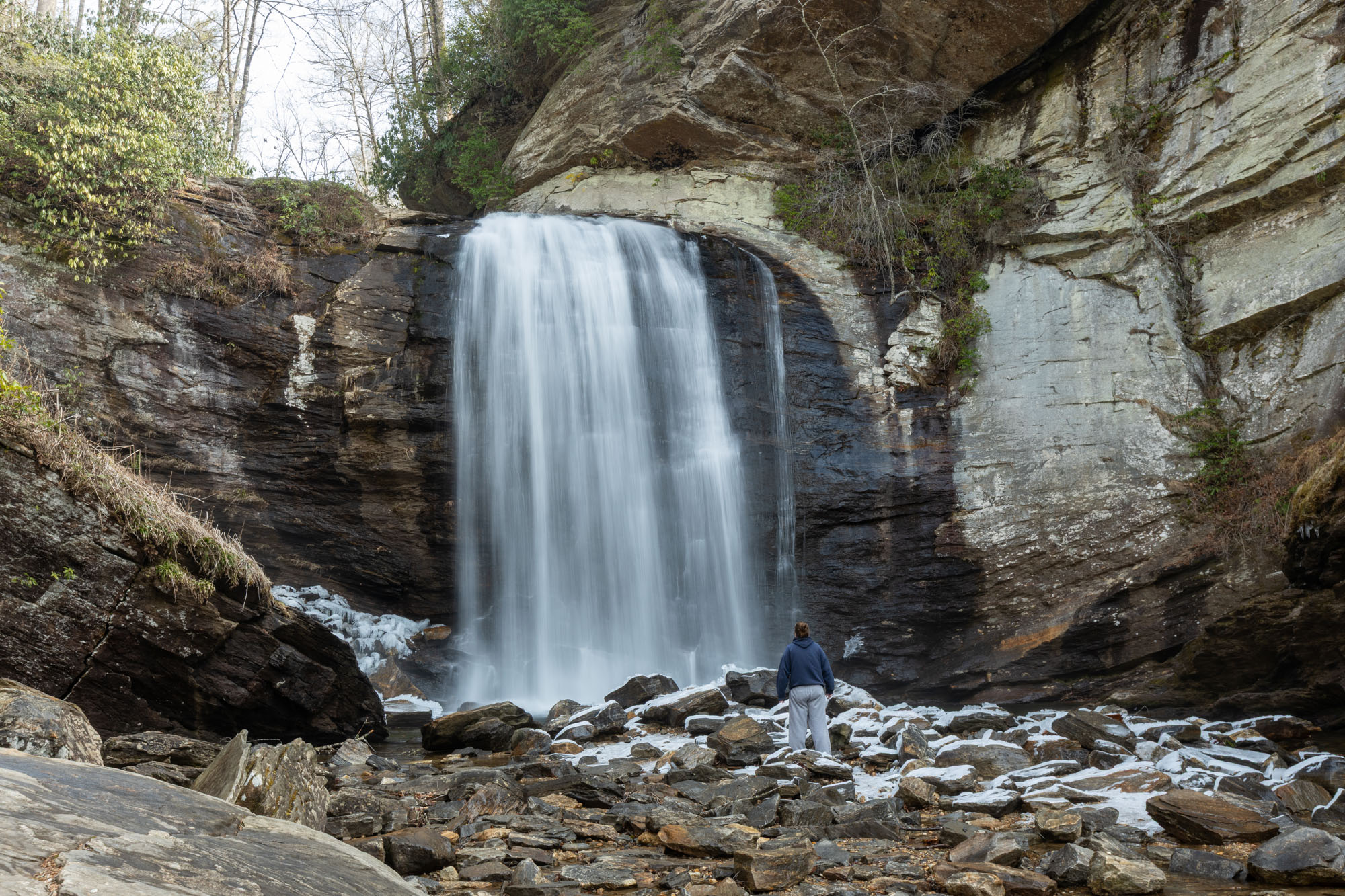 Looking Glass Falls from creek level with person for scale