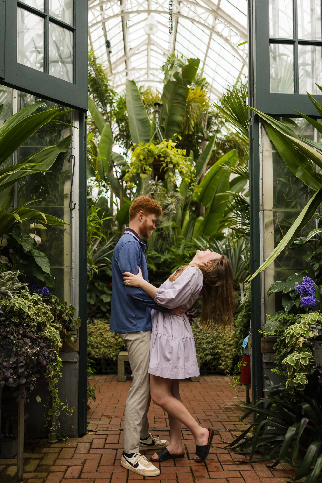 Couple inside the Biltmore Conservatory surrounded by tropical plants during an engagement session
