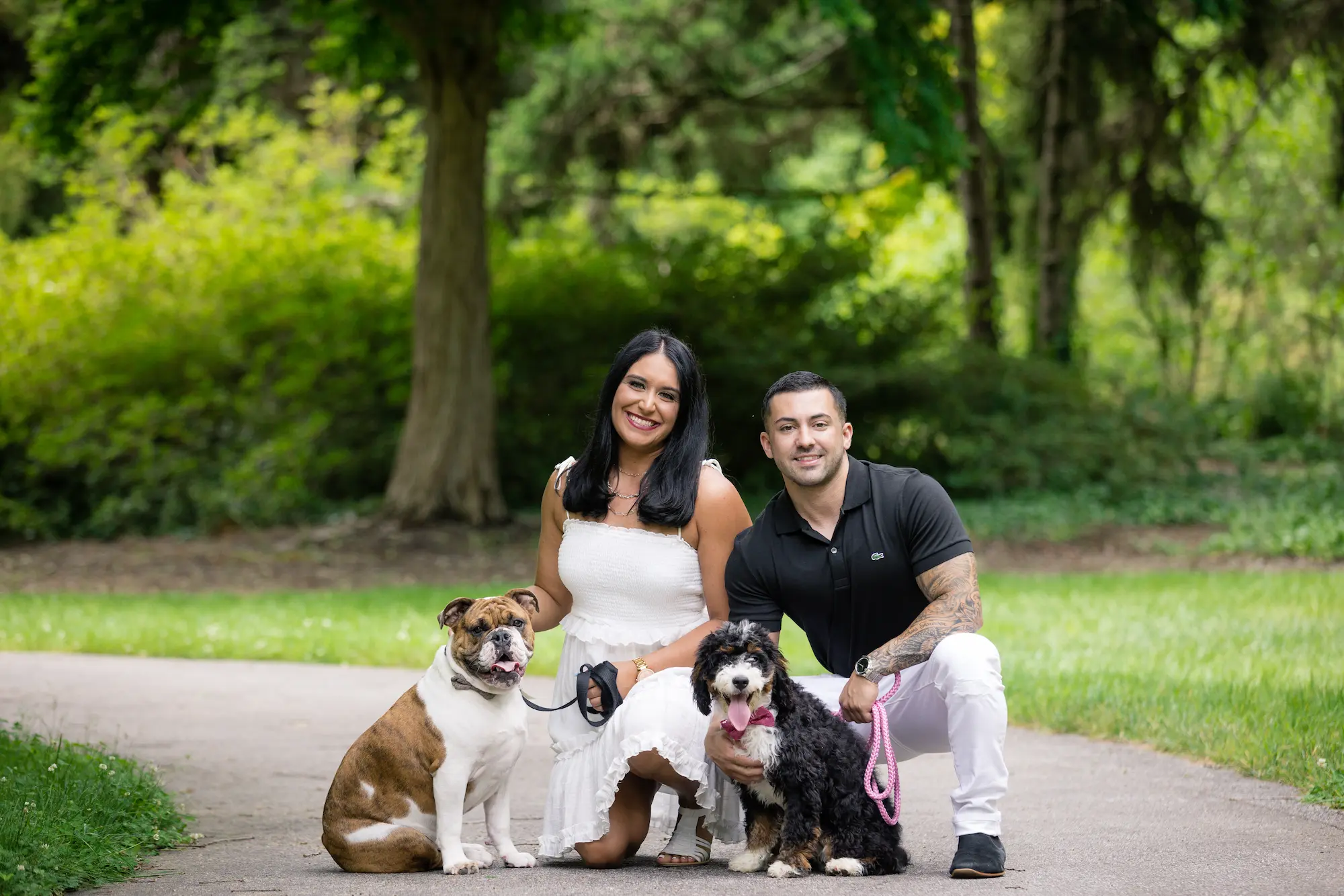 Engaged couple posing with their dogs during an engagement session in the gardens at Biltmore Estate