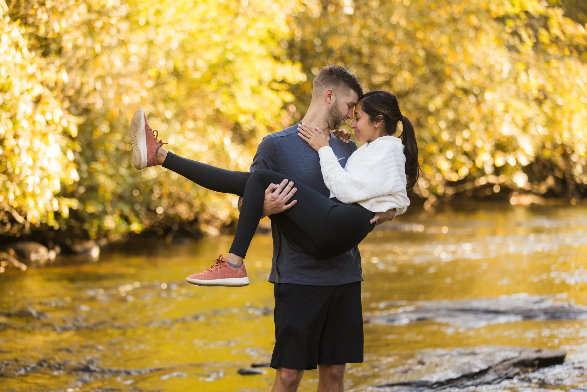 Carrying her across golden river light, autumn engagement photos DuPont NC