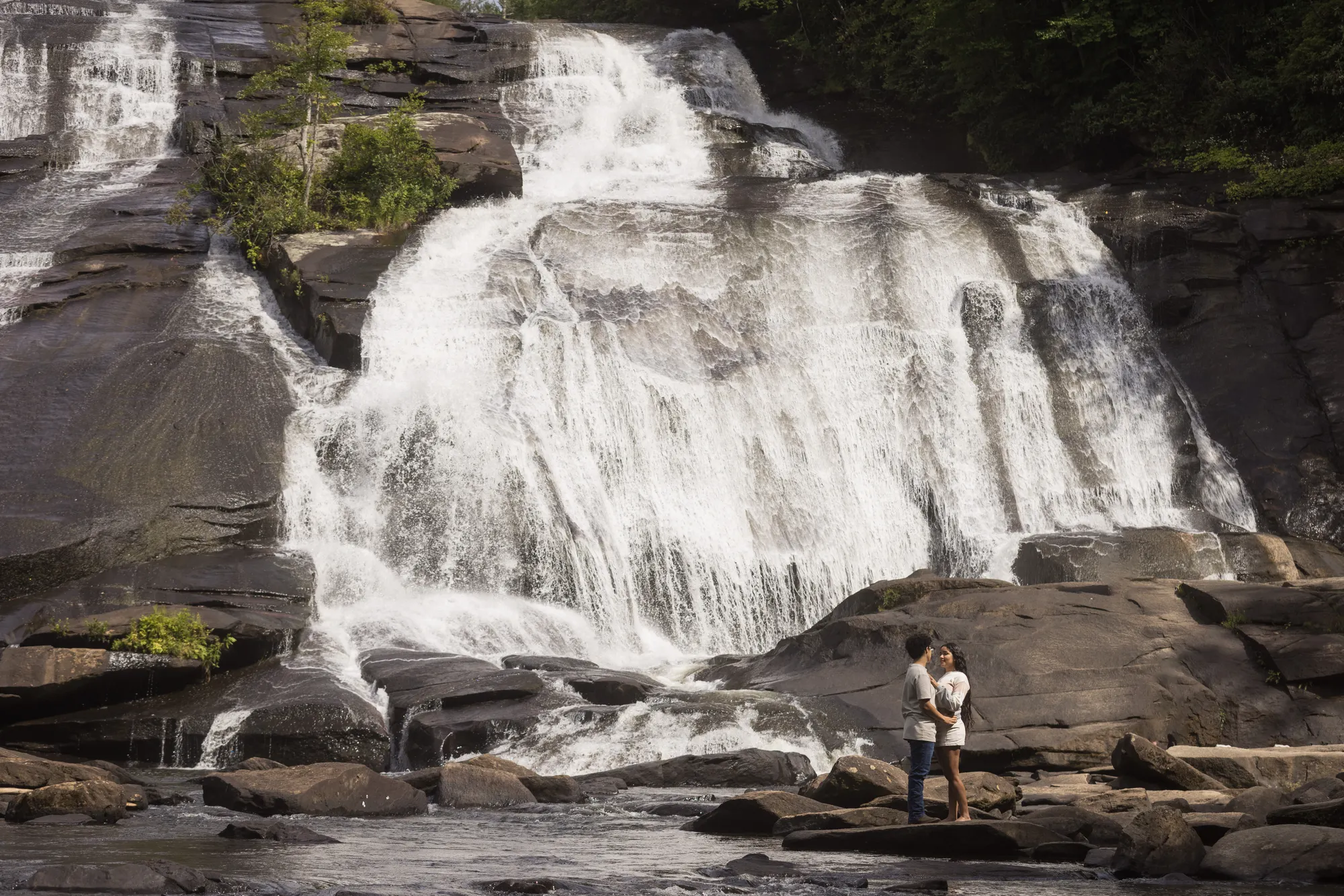 Couple dwarfed by the 150-foot wall of High Falls, DuPont State Forest