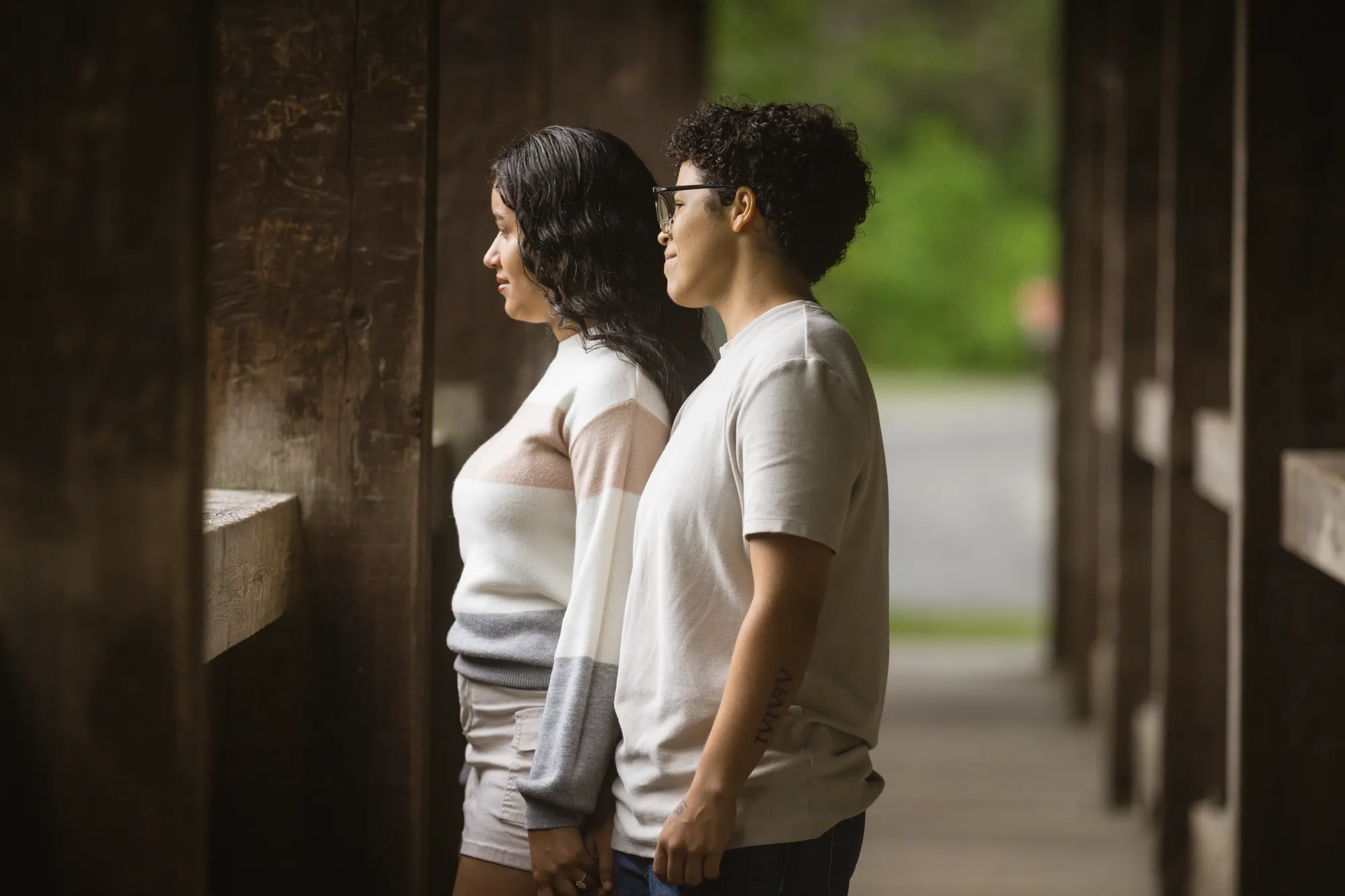 Couple framed by warm wood tones inside the DuPont covered bridge