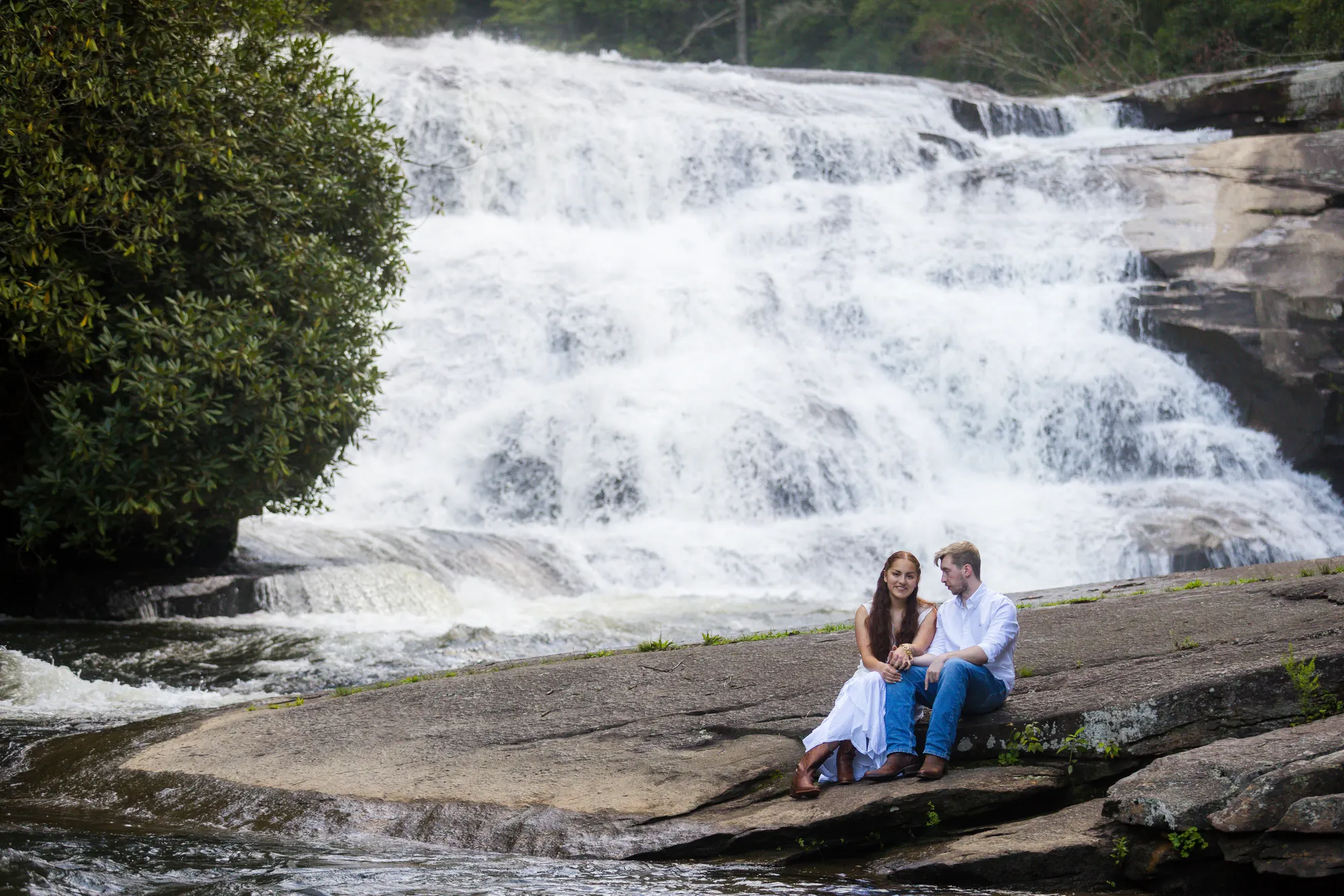 Couple sitting below the falls, DuPont State Forest