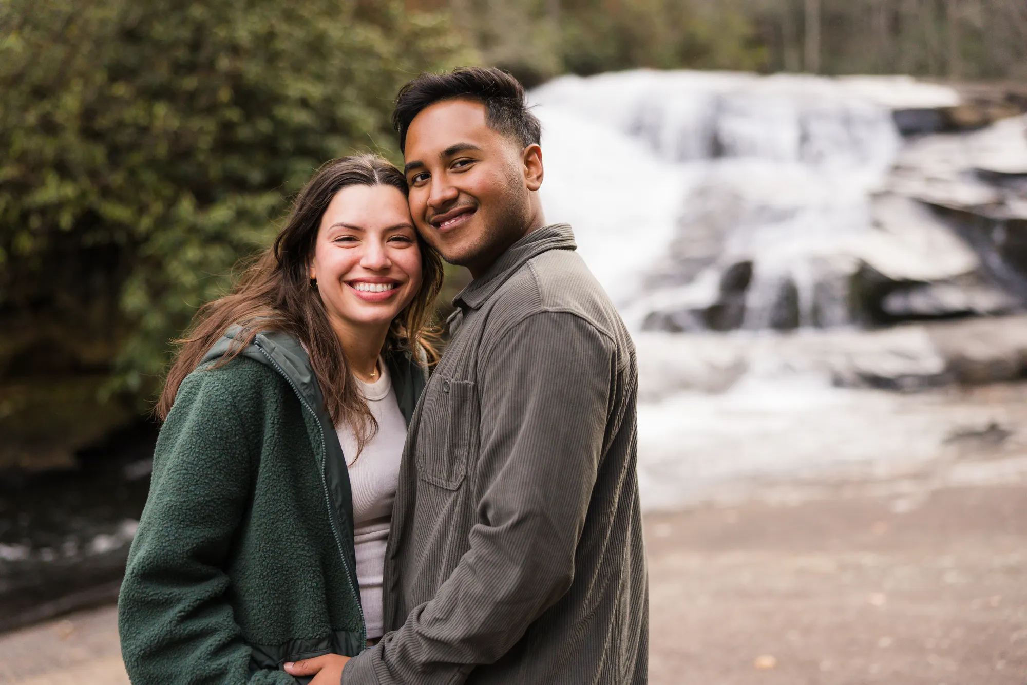 Smiling engaged couple portrait with Triple Falls behind, DuPont