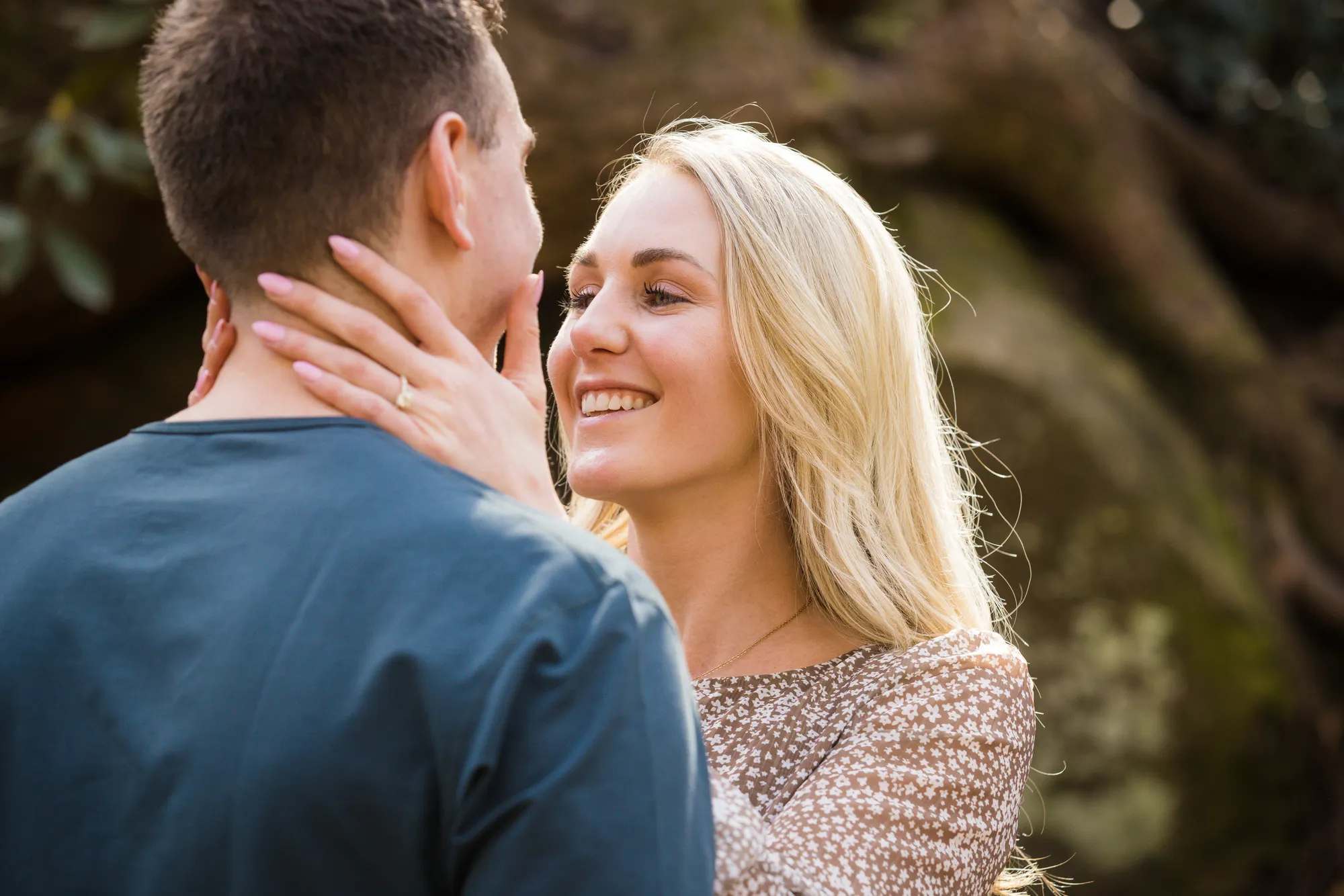 Engagement ring visible as she touches his face, DuPont State Forest
