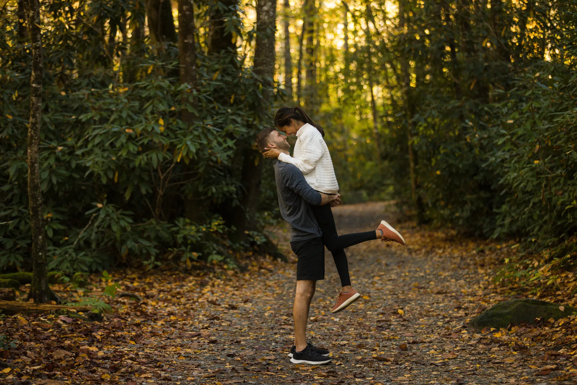 Lift and kiss on the trail, fall engagement session DuPont State Forest
