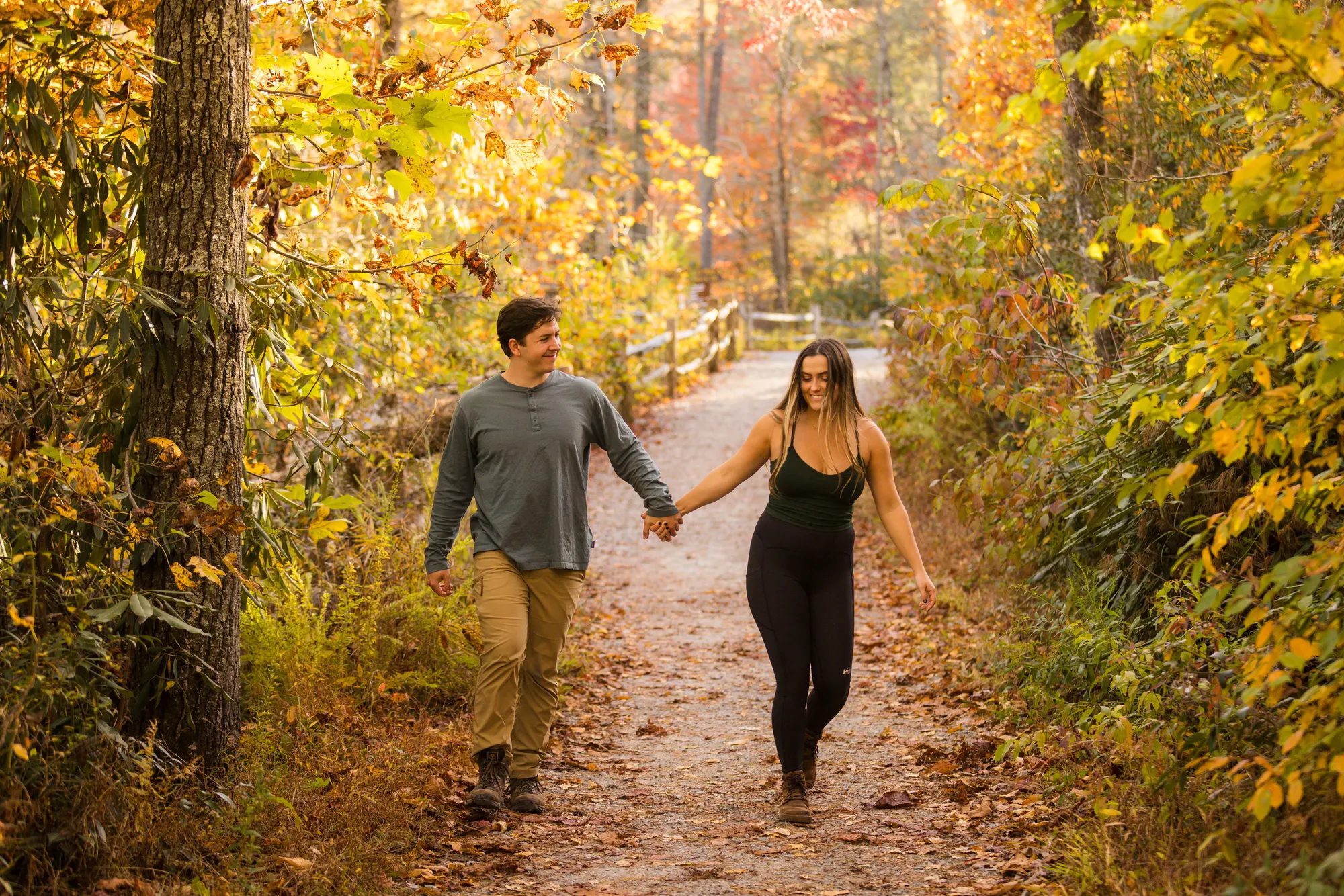 Couple walking a fall-color trail after their proposal, DuPont State Forest