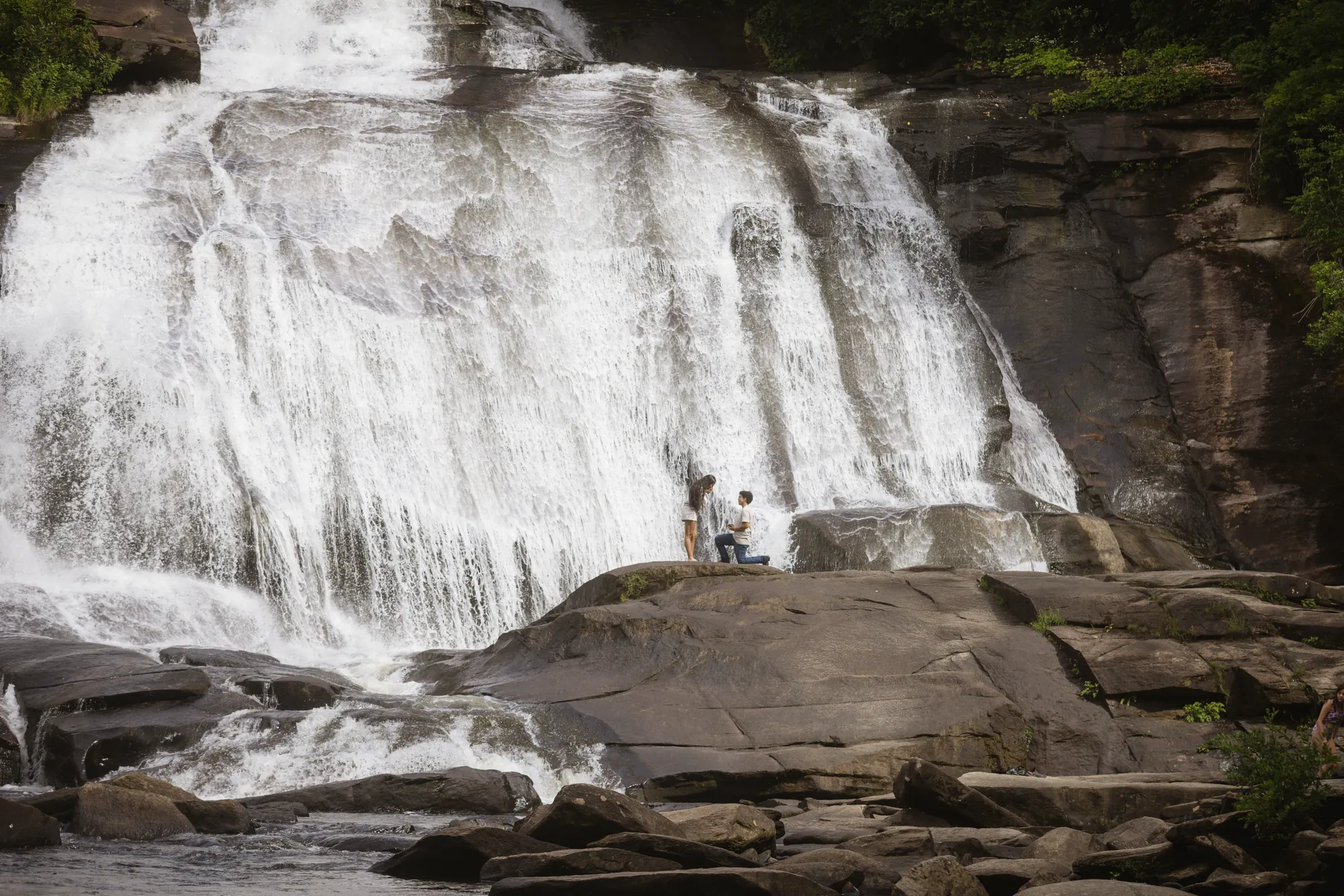 The 150-foot High Falls with a couple on the rocks below, DuPont State Forest