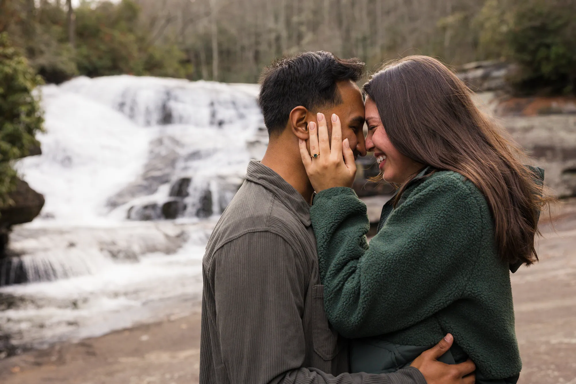 Forehead-to-forehead just-engaged couple at Triple Falls, DuPont NC