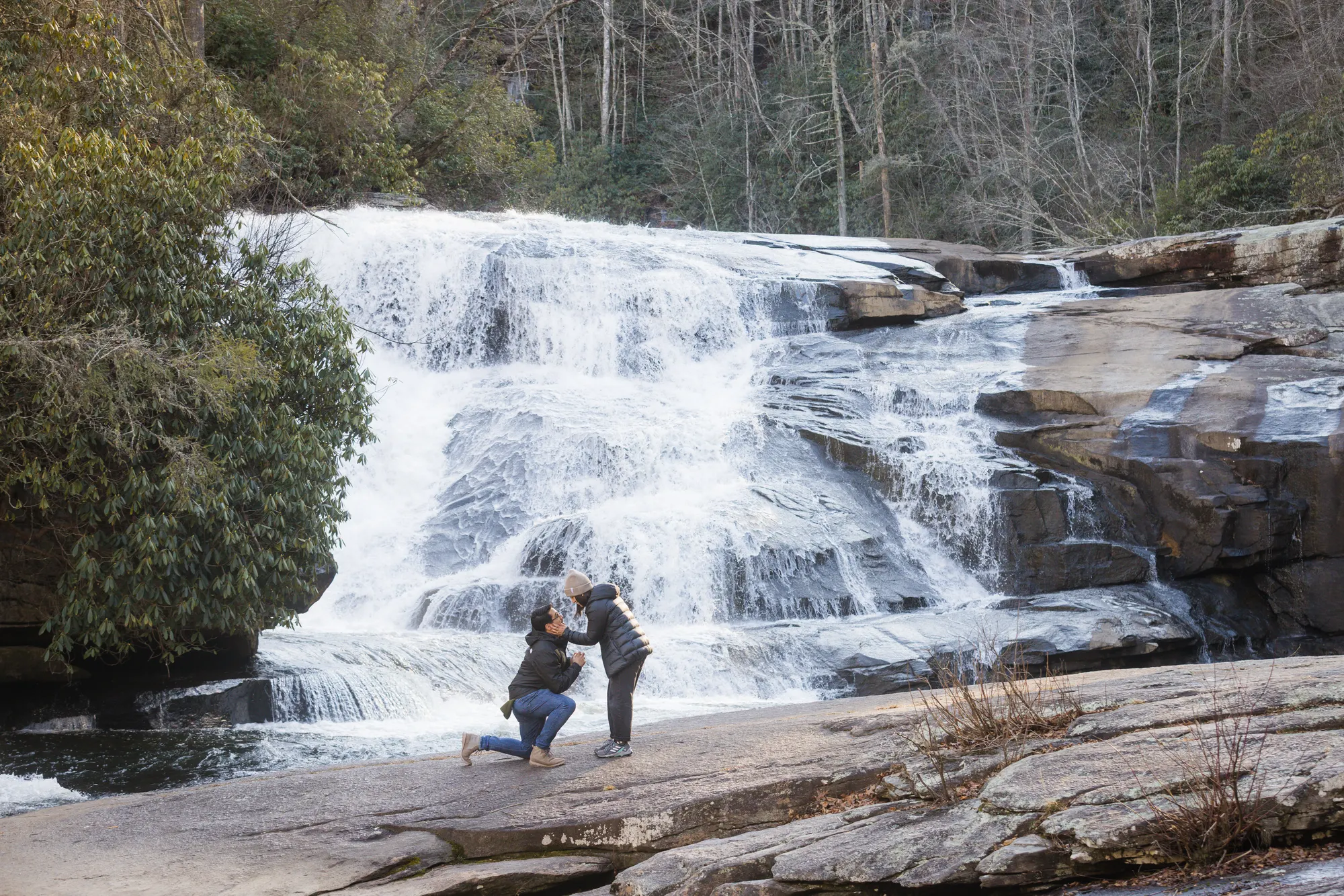 Surprise proposal at Triple Falls in winter with ice on the rocks, DuPont NC