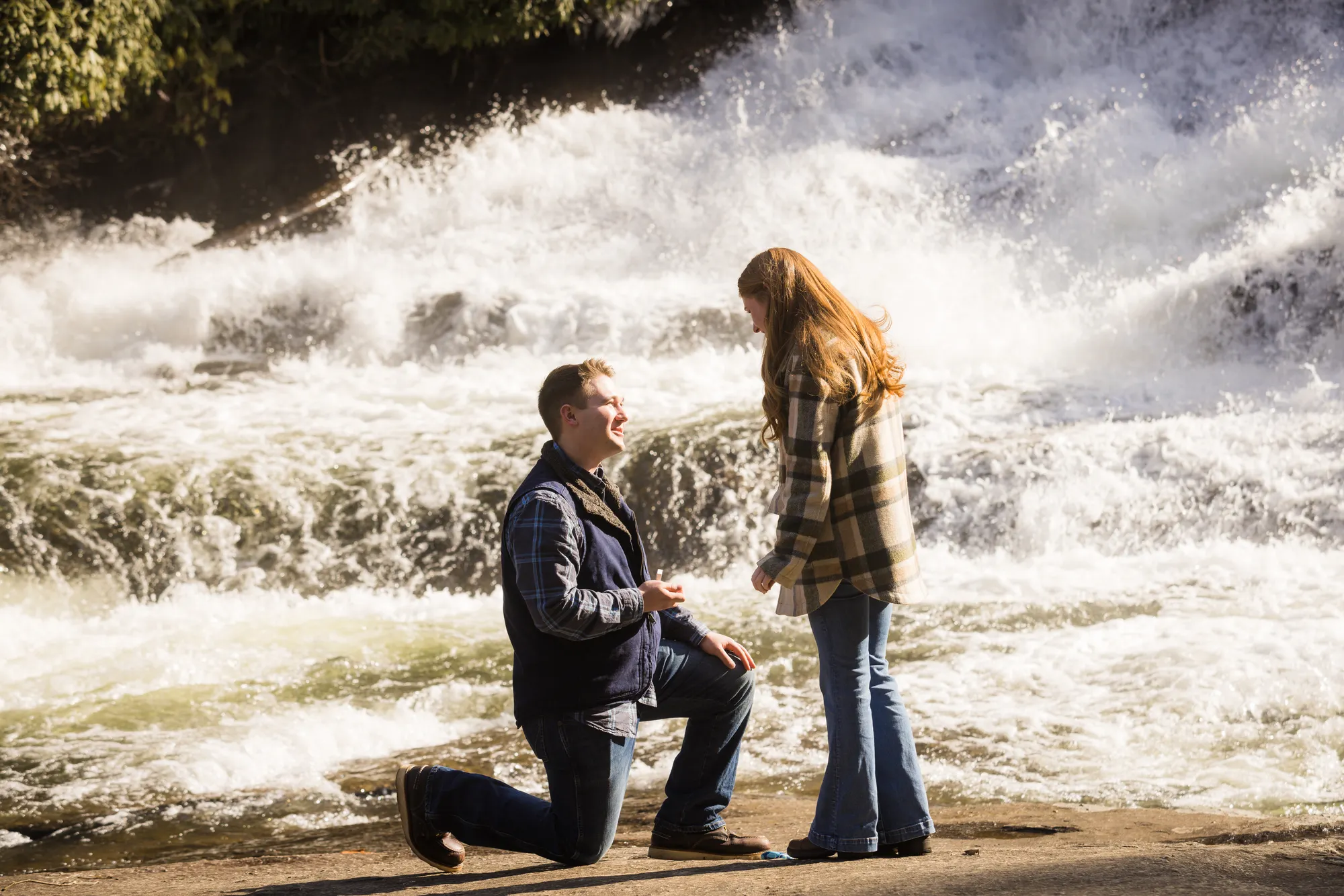 Backlit surprise proposal in front of rushing whitewater, DuPont State Forest