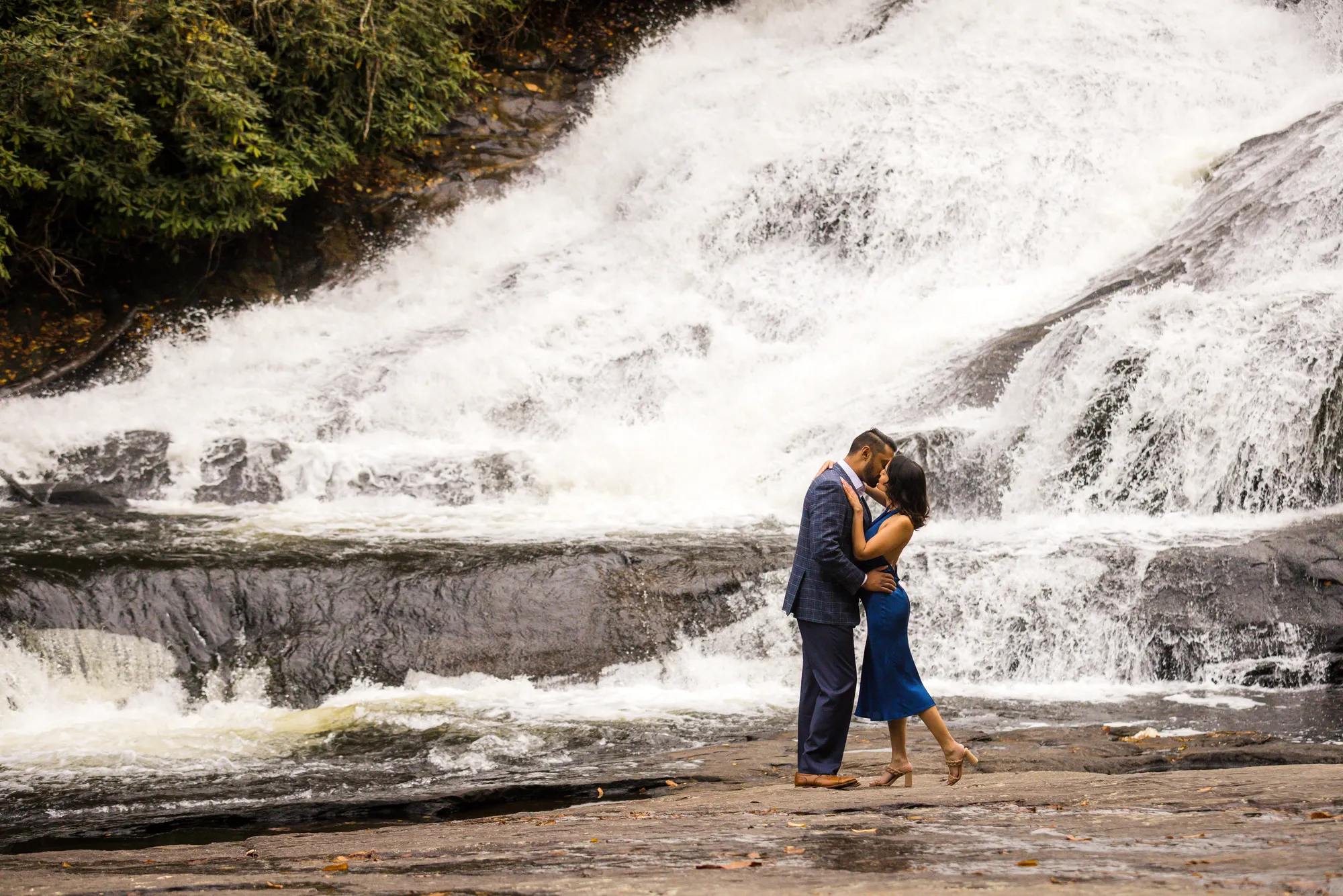 Engagement photos at Triple Falls, DuPont State Forest, couple kissing on the granite shelf