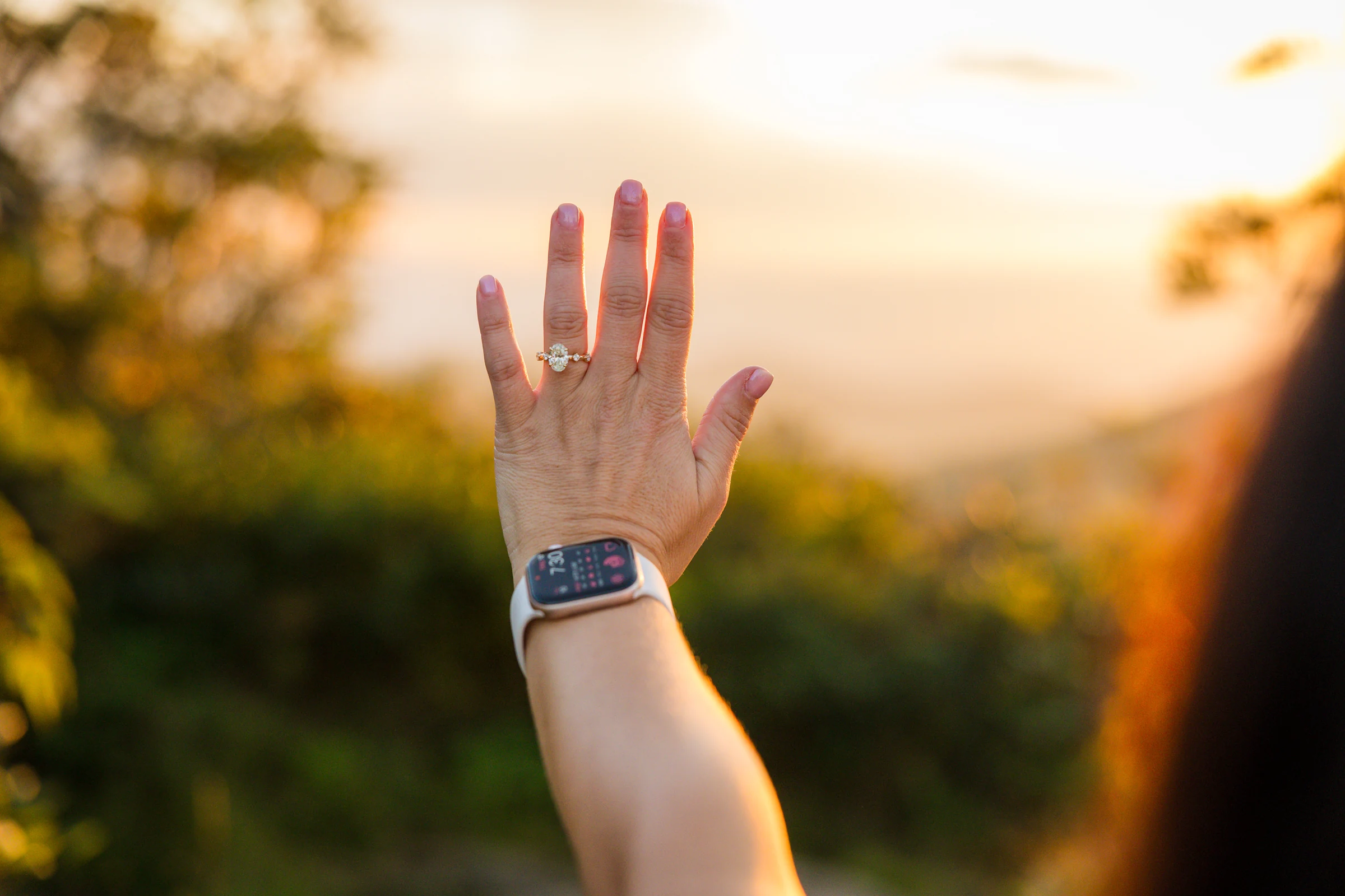 Close detail of Jaci's engagement ring after the proposal on Craggy Pinnacle, warm sunset light