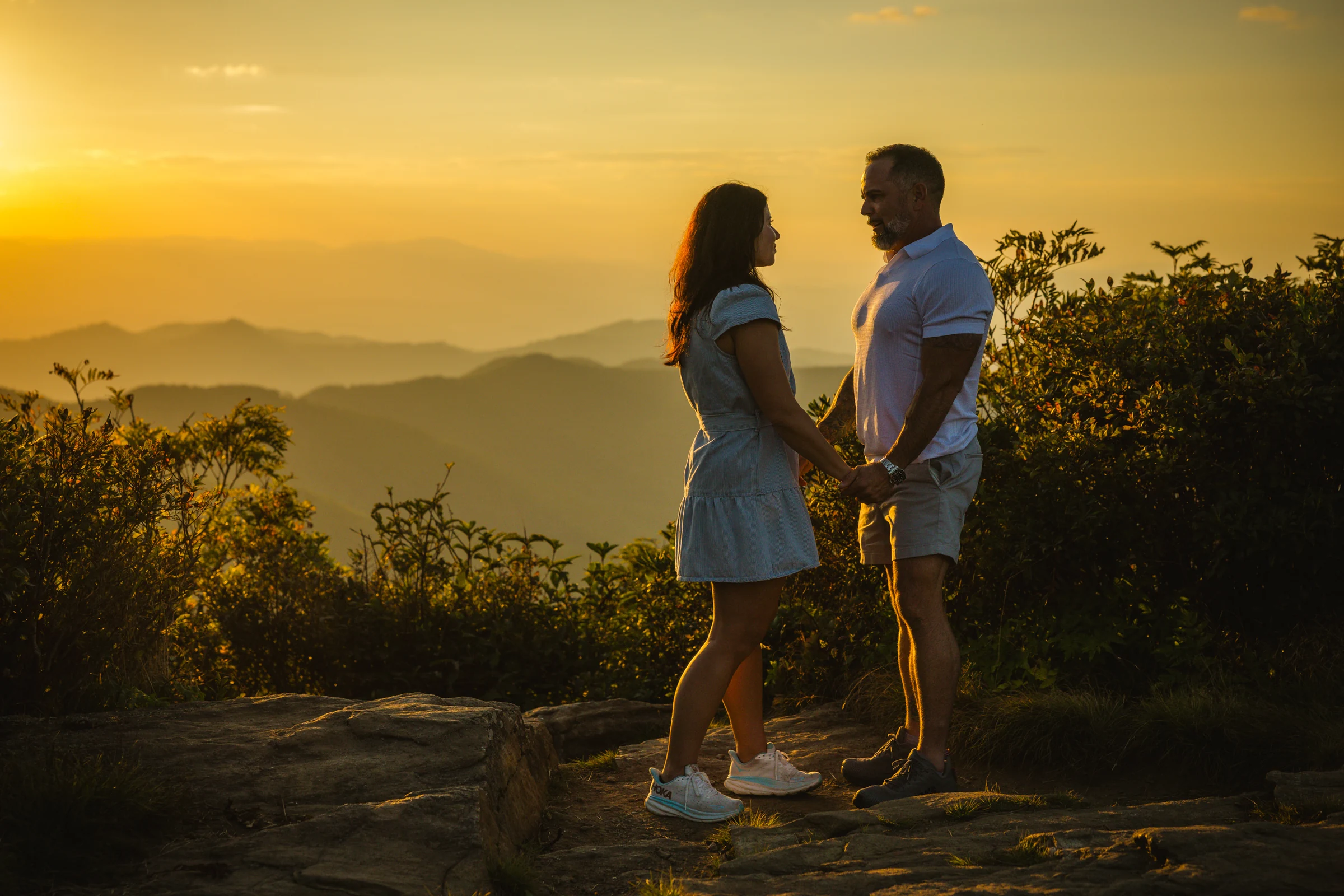 Engagement portrait of Scott and Jaci beneath a golden sky on Craggy Pinnacle, Blue Ridge Parkway near Asheville NC