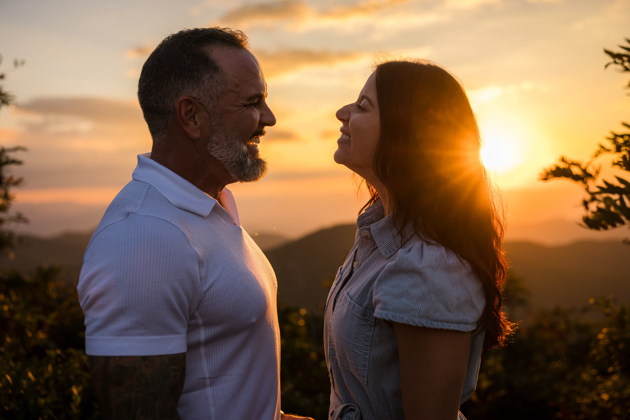 Close portrait of Scott and Jaci with a sunburst behind them on Craggy Pinnacle at sunset, Asheville NC