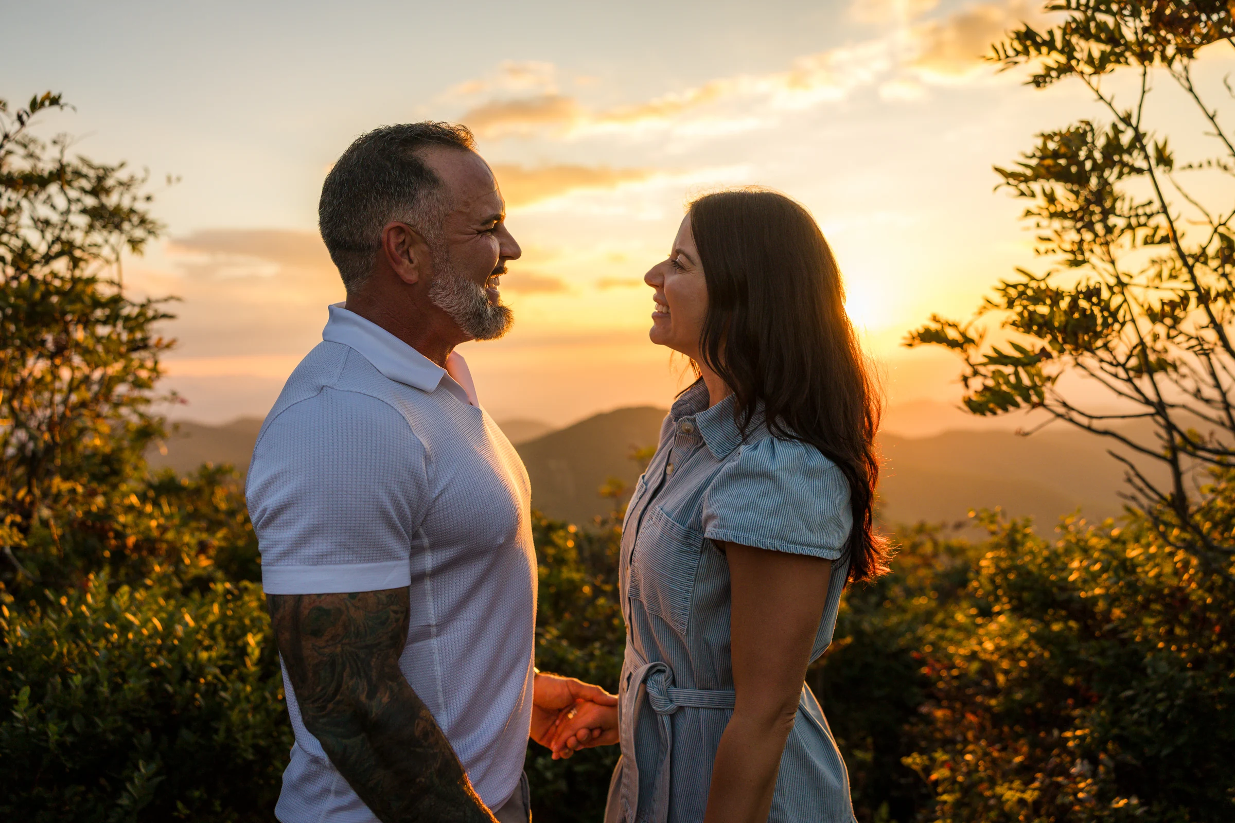 Scott and Jaci with a sunburst over the Blue Ridge Mountains behind them on Craggy Pinnacle
