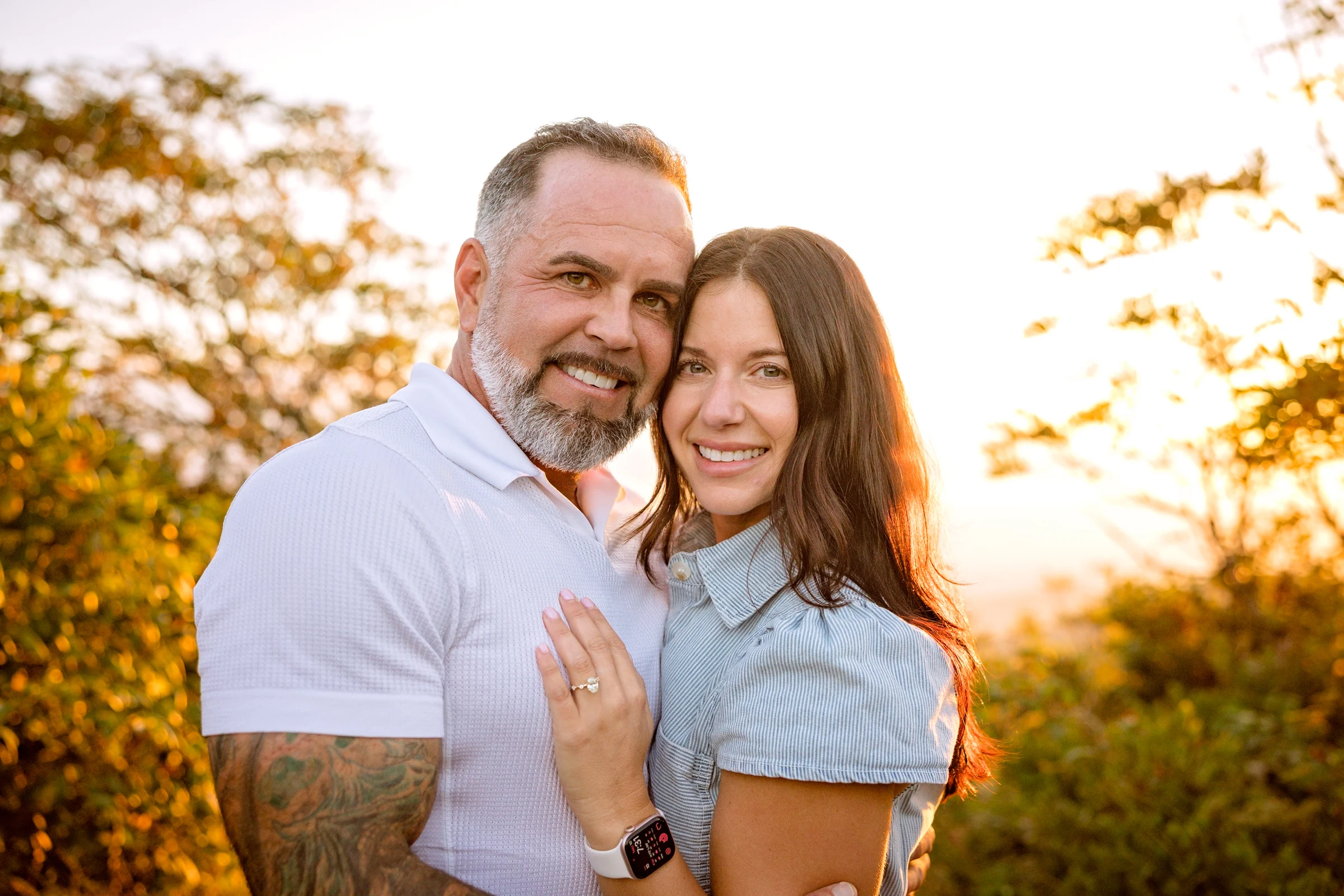 Scott and Jaci in warm sunlight on Craggy Pinnacle after their proposal, mountains behind them