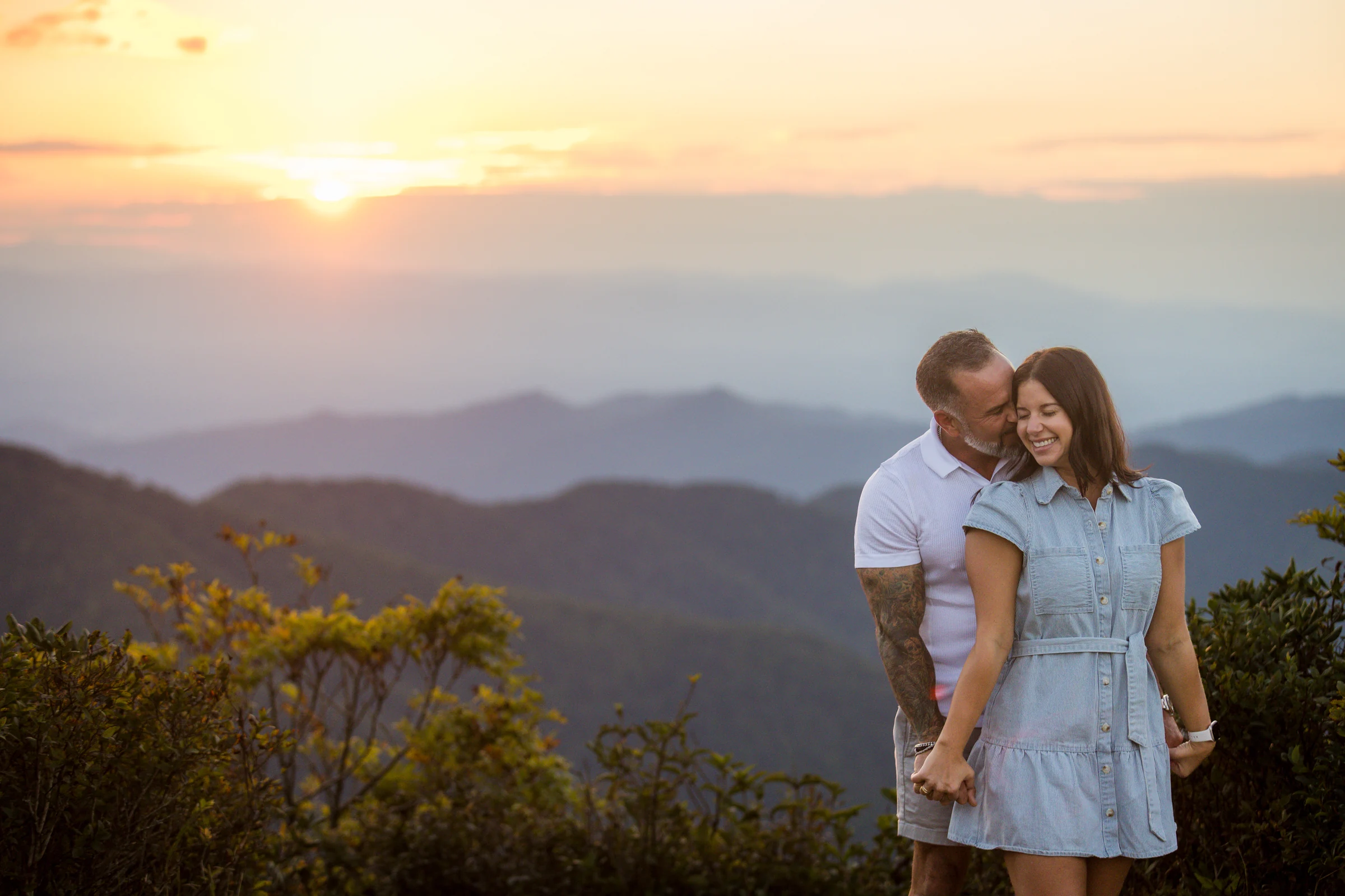 Jaci smiling at sunset on Craggy Pinnacle after the proposal, Blue Ridge Mountains behind her