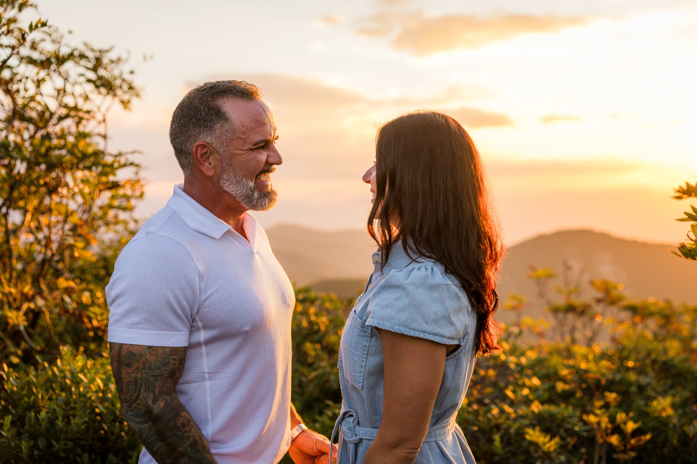 Scott and Jaci facing the sunset from the west ledge of Craggy Pinnacle, the Blue Ridge Mountains fading into the haze