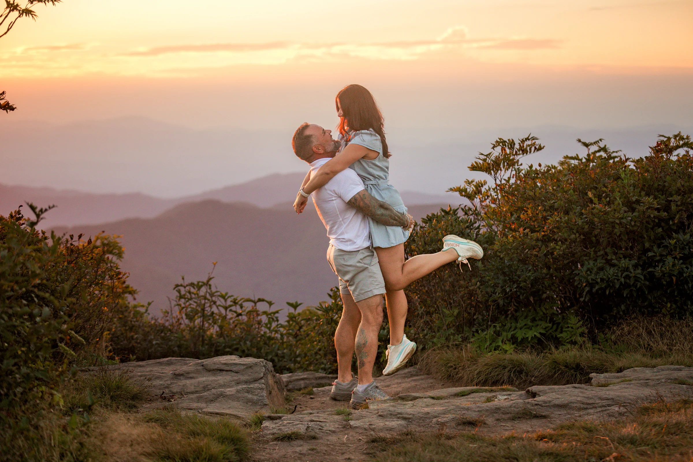 Scott lifts Jaci against a sunset sky on Craggy Pinnacle, Blue Ridge Parkway, Asheville NC